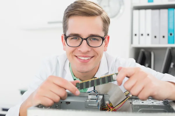 Tecnico sorridente che lavora su cpu rotto — Foto Stock