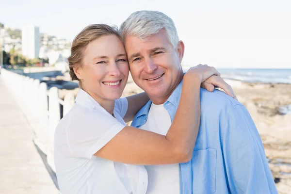 Happy casual couple hugging by the coast — Stock Photo, Image