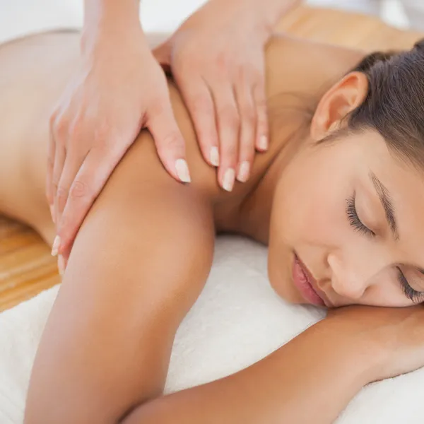 Beautiful brunette enjoying shoulder massage — Stock Photo, Image