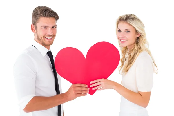 Atraente jovem casal segurando coração vermelho — Fotografia de Stock