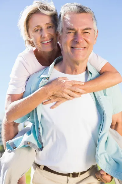 Glücklicher Senior gibt seiner Partnerin ein Huckepack zurück — Stockfoto