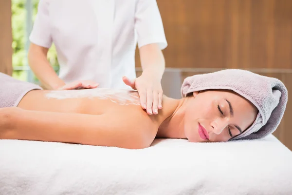 Attractive woman receiving back mask cream at spa center — Stock Photo, Image