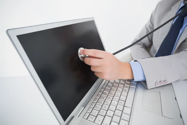 Technician listening to laptop with stethoscope — Stock Photo, Image