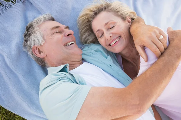 Happy senior couple cuddling on blanket — Stock Photo, Image