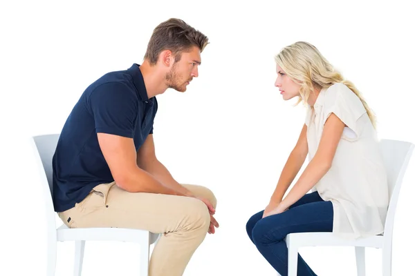 Young couple sitting in chairs arguing — Stock Photo, Image