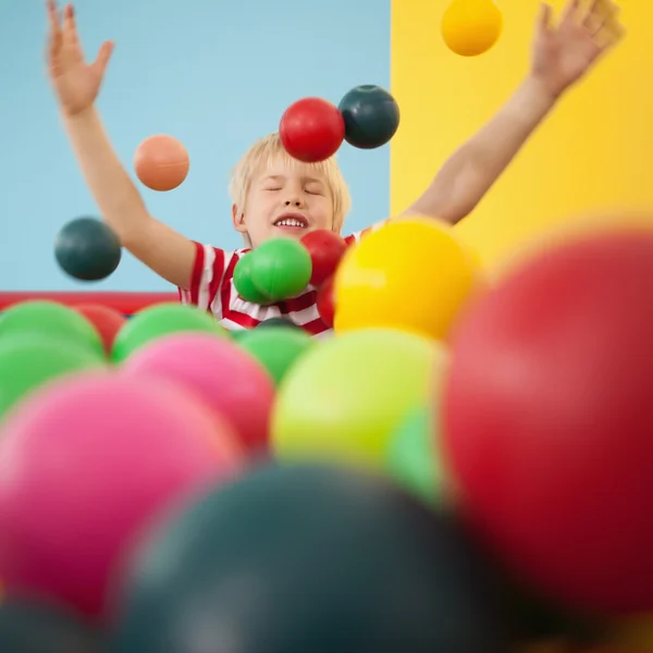 Niño feliz jugando en la piscina de pelota — Foto de Stock