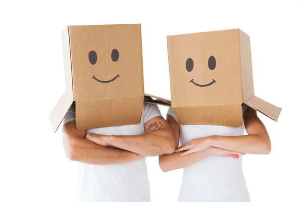 Casal usando caixas de rosto sorridente em suas cabeças — Fotografia de Stock