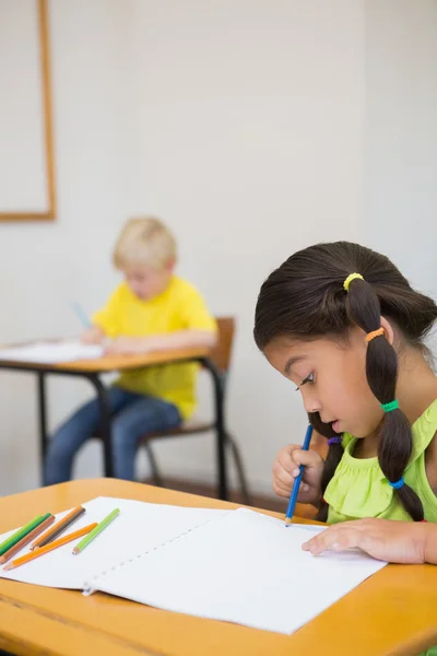 Leerlingen kleuren bij bureaus in klas — Stockfoto