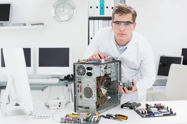 Jovem técnico trabalhando em computador quebrado — Fotografia de Stock