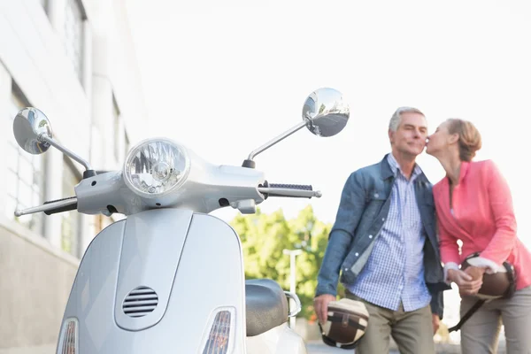 Felice coppia anziana in posa con il loro ciclomotore — Foto Stock