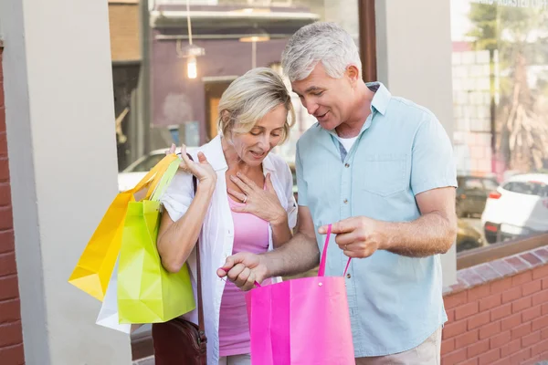 Feliz casal maduro olhando para suas compras — Fotografia de Stock