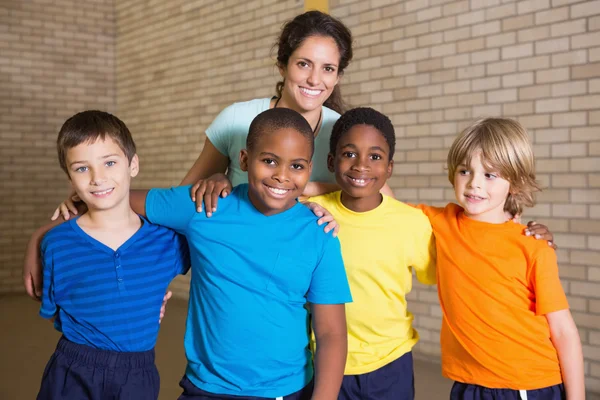 Pupils smiling at camera with PE teacher — Stock Photo, Image