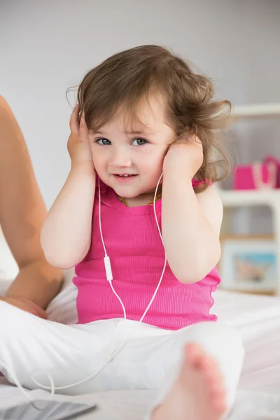 Söt liten flicka lyssna på musik på sängen — Stockfoto