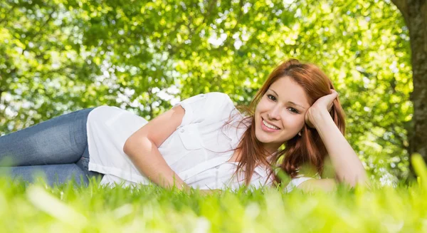 Redhead liggen op het gras — Stockfoto