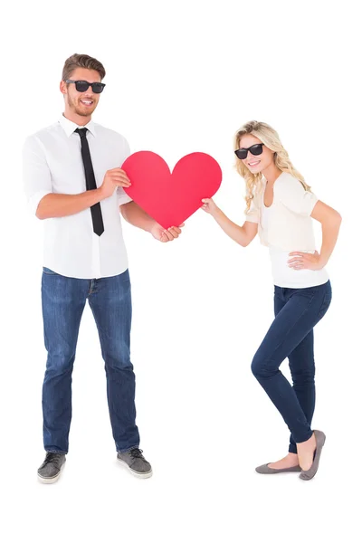 Cool young couple holding red heart — Stock Photo, Image