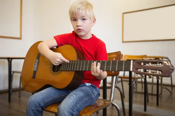 Pupil playing guitar in classroom — Stock Photo, Image