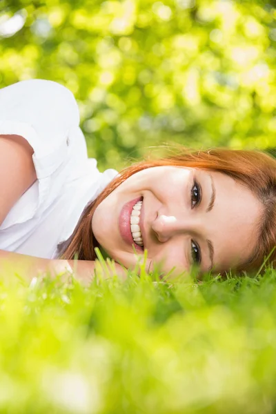 Mooie roodharige liggen op het gras — Stockfoto