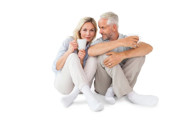 Feliz casal sentado segurando canecas — Fotografia de Stock