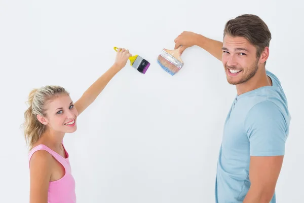 Young couple painting with brushes — Stock Photo, Image