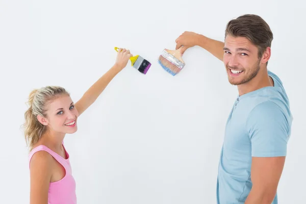 Pareja joven pintando con pinceles — Foto de Stock