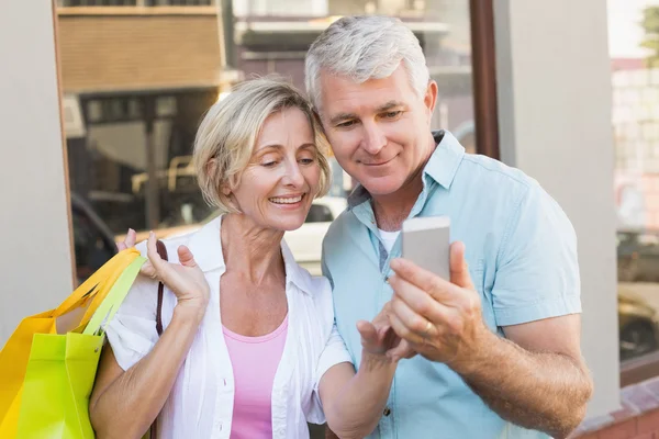 Счастливая пара смотрит на смартфон вместе — стоковое фото