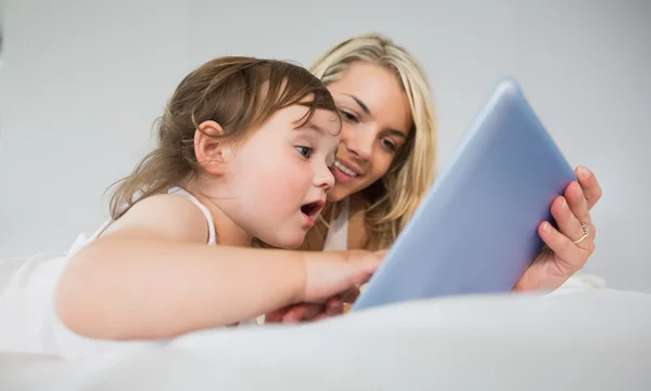 Mère et fille utilisant une tablette numérique sur le lit — Photo