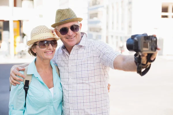 Happy tourist couple taking a selfie in the city — Stock Photo, Image