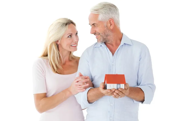 Casal feliz segurando casa modelo em miniatura — Fotografia de Stock