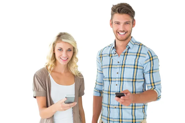Atractiva pareja usando sus teléfonos inteligentes — Foto de Stock