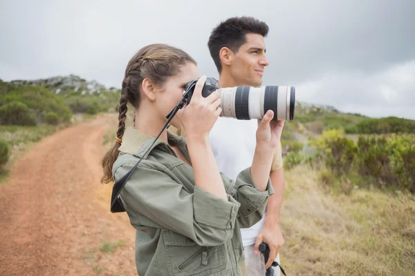 Pareja tomando fotos en terreno de montaña — Foto de Stock