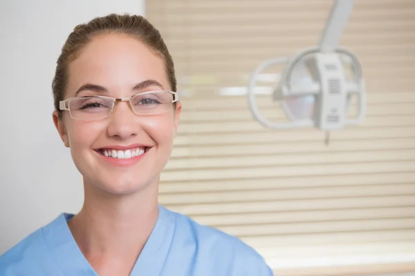 Dentiste en blouse bleue regardant la caméra — Photo