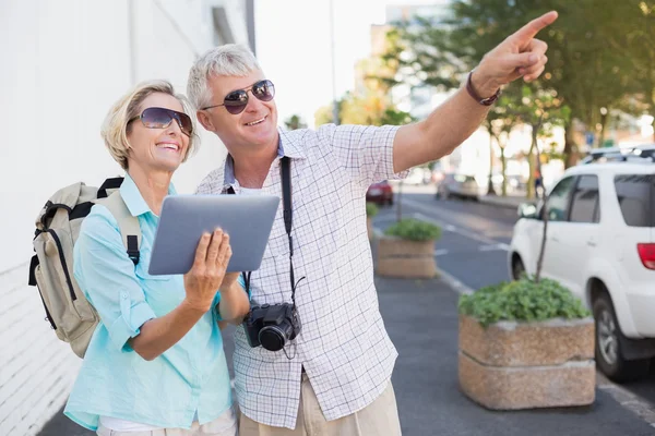 Feliz pareja de turistas utilizando la tableta en la ciudad —  Fotos de Stock