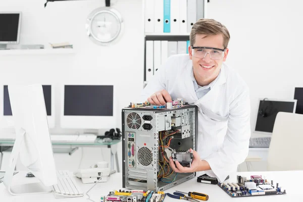 Jovem técnico trabalhando em computador quebrado — Fotografia de Stock