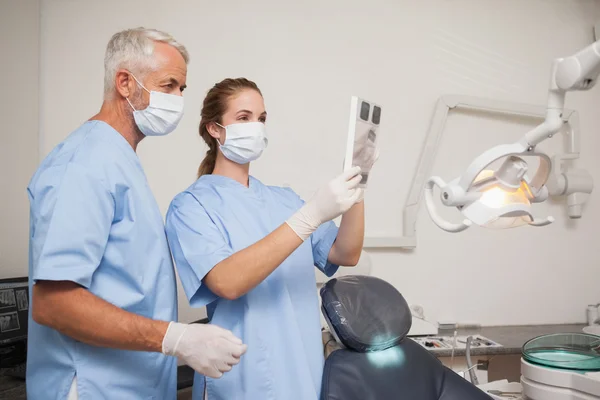 Dentista y asistente sonriendo a la cámara — Foto de Stock
