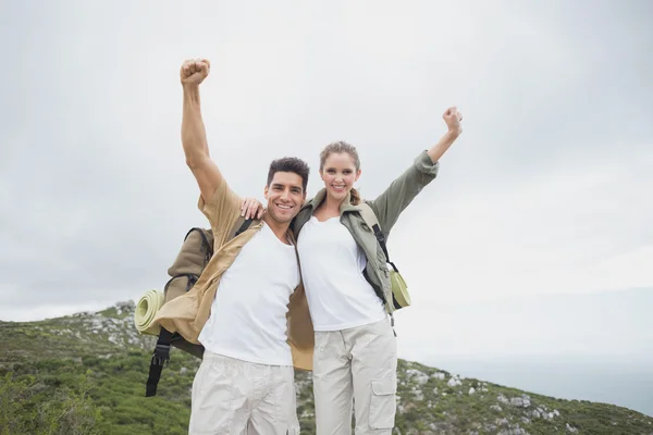 Pareja de senderismo estirando las manos en terreno de montaña — Foto de Stock