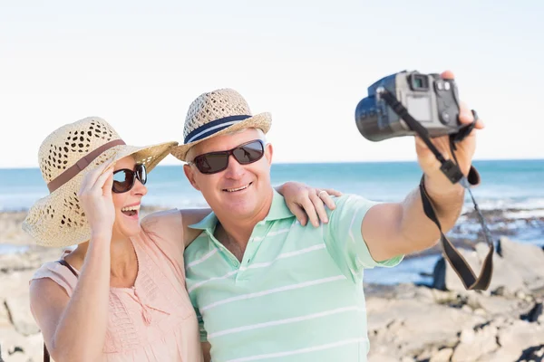 Casal feliz tomando uma selfie pela costa — Fotografia de Stock