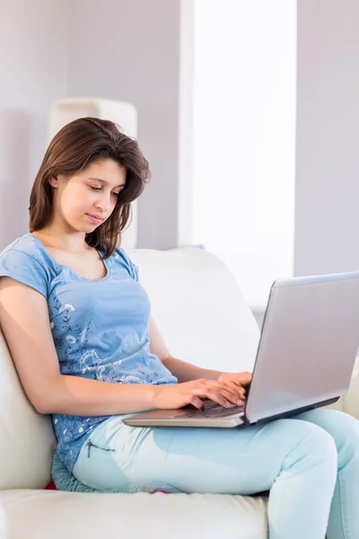 Ziemlich brünett relaxen auf der couch mit laptop — Stockfoto