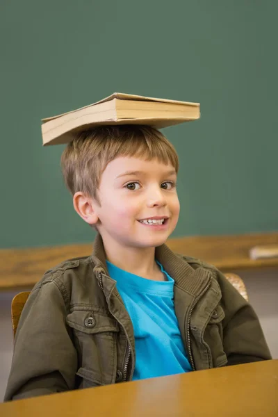Leerling balancing boek over zijn hoofd — Stockfoto