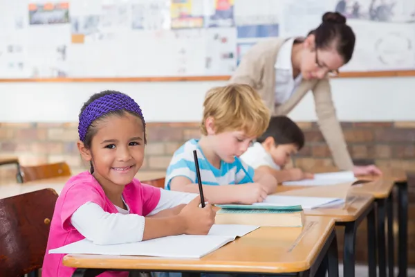 Lindos alumnos dibujando en sus escritorios — Foto de Stock