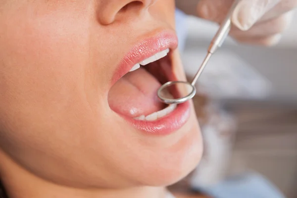 Dentista examinando los dientes de un paciente — Foto de Stock