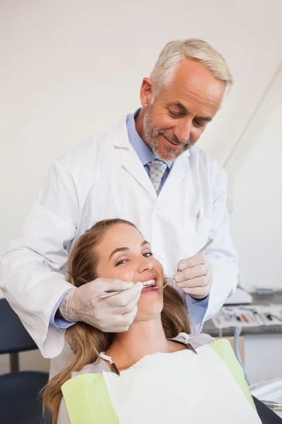 Dentista examinando los dientes de un paciente — Foto de Stock