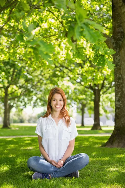 Hübscher Rotschopf lächelt im Park in die Kamera — Stockfoto