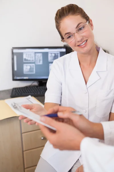 Dentista y asistente estudiando rayos X en la computadora — Foto de Stock