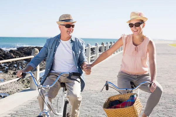 Happy casual couple going for a bike ride on the pier — Stock Photo, Image