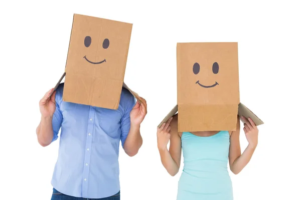 Couple wearing emoticon face boxes on their heads — Stock Photo, Image