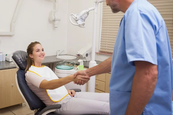 Zahnarzt schüttelt seiner Patientin die Hand — Stockfoto