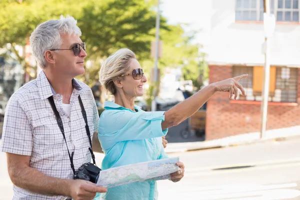 Happy tourist couple using map in the city — Stock Photo, Image