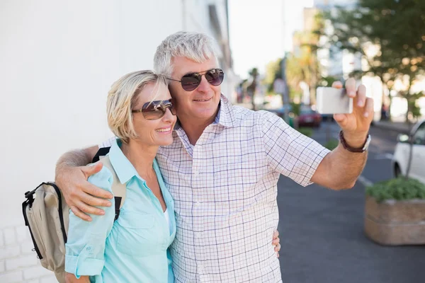 Heureux couple de touristes prenant un selfie dans la ville — Photo