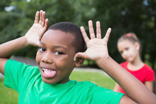 Pequeño niño haciendo caras tontas afuera — Foto de Stock