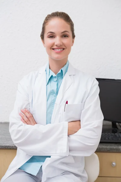 Tandarts zit aan Bureau glimlachen op camera — Stockfoto